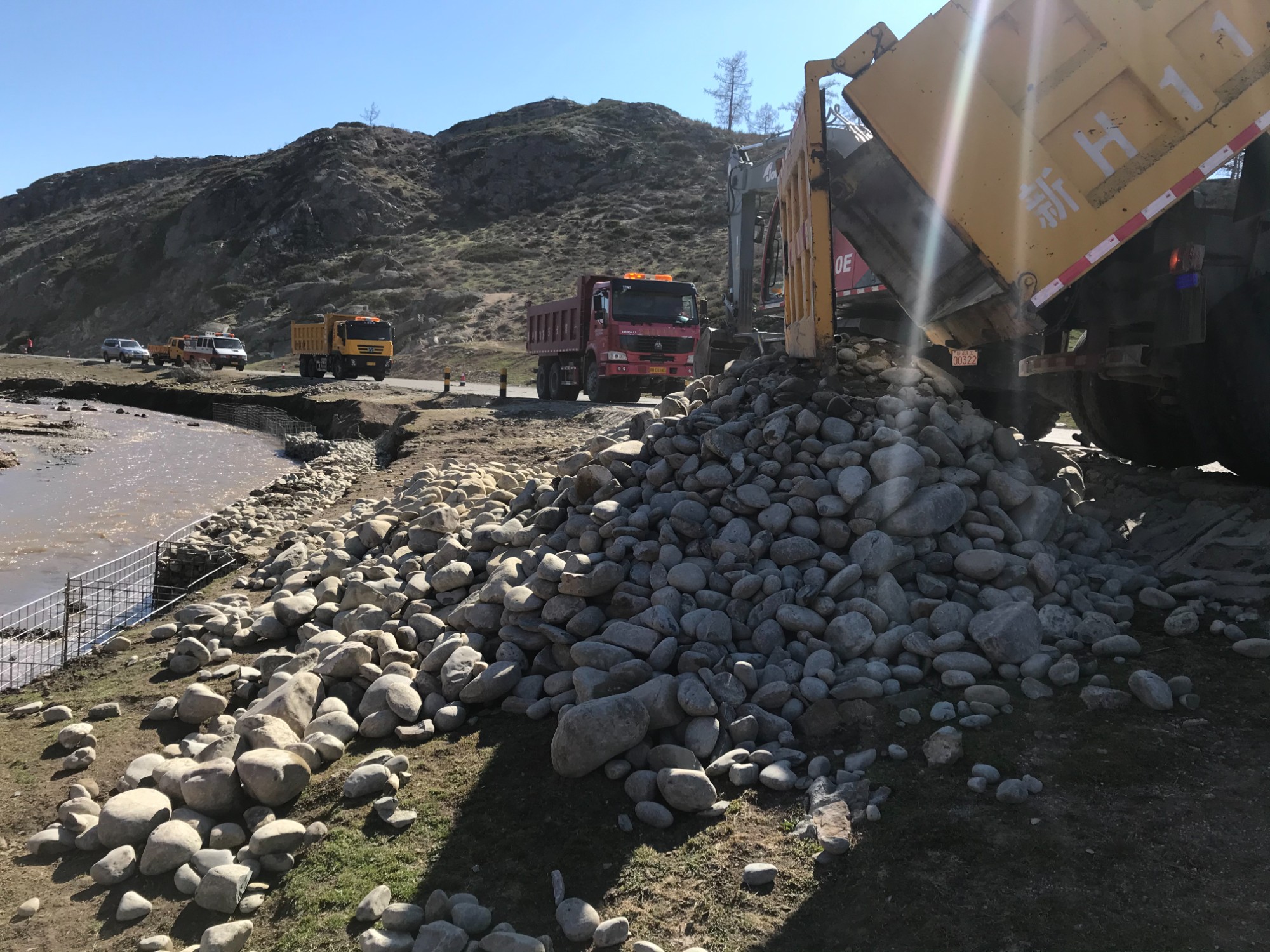 哈巴河公路管理分局自卸车拉运鹅卵石倒至现场  图：蒋磊.jpg