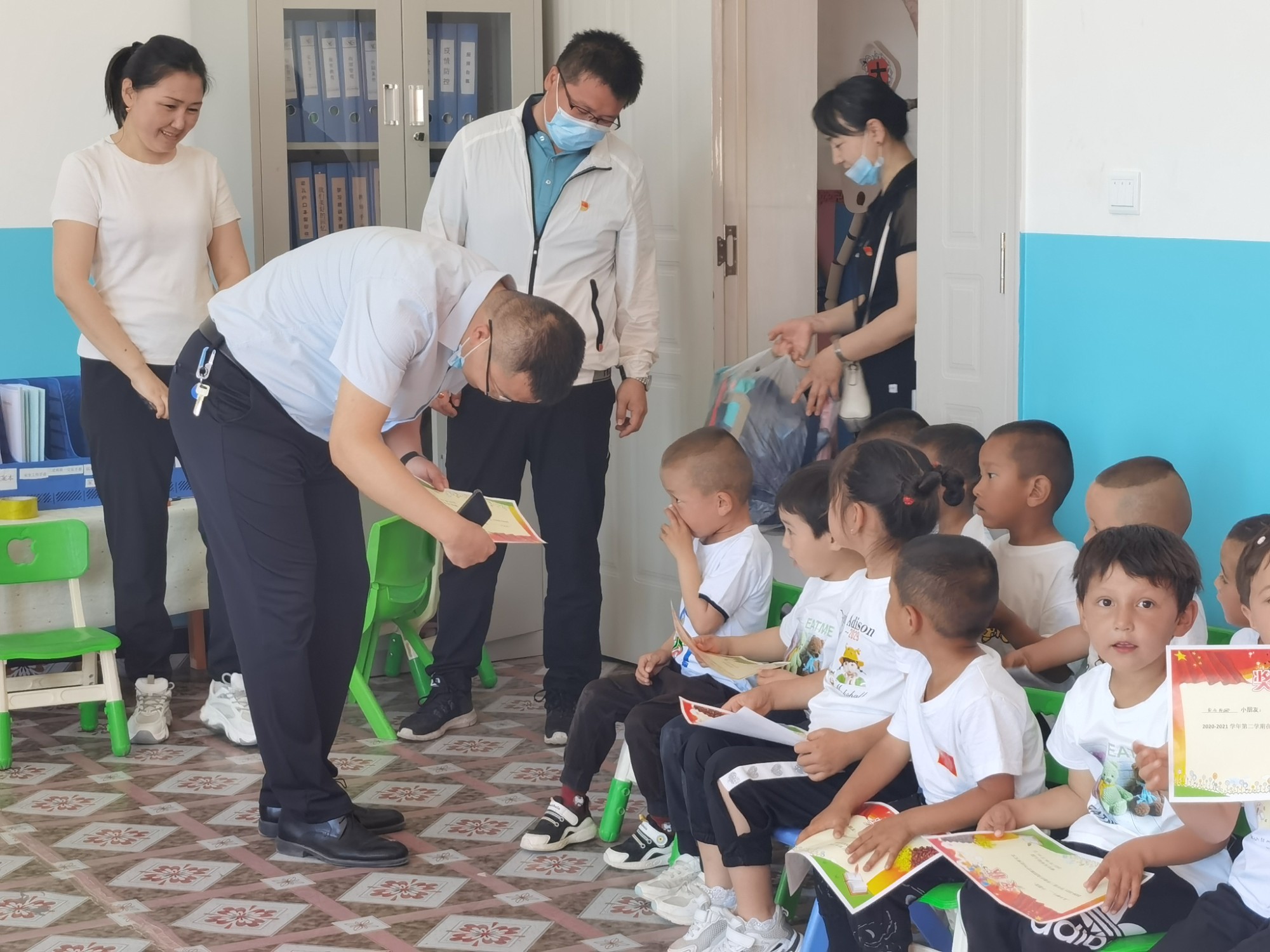 哈巴河公路管理分局党组书记、副局长李翔给孩子们发放奖状  图：马晨.jpg