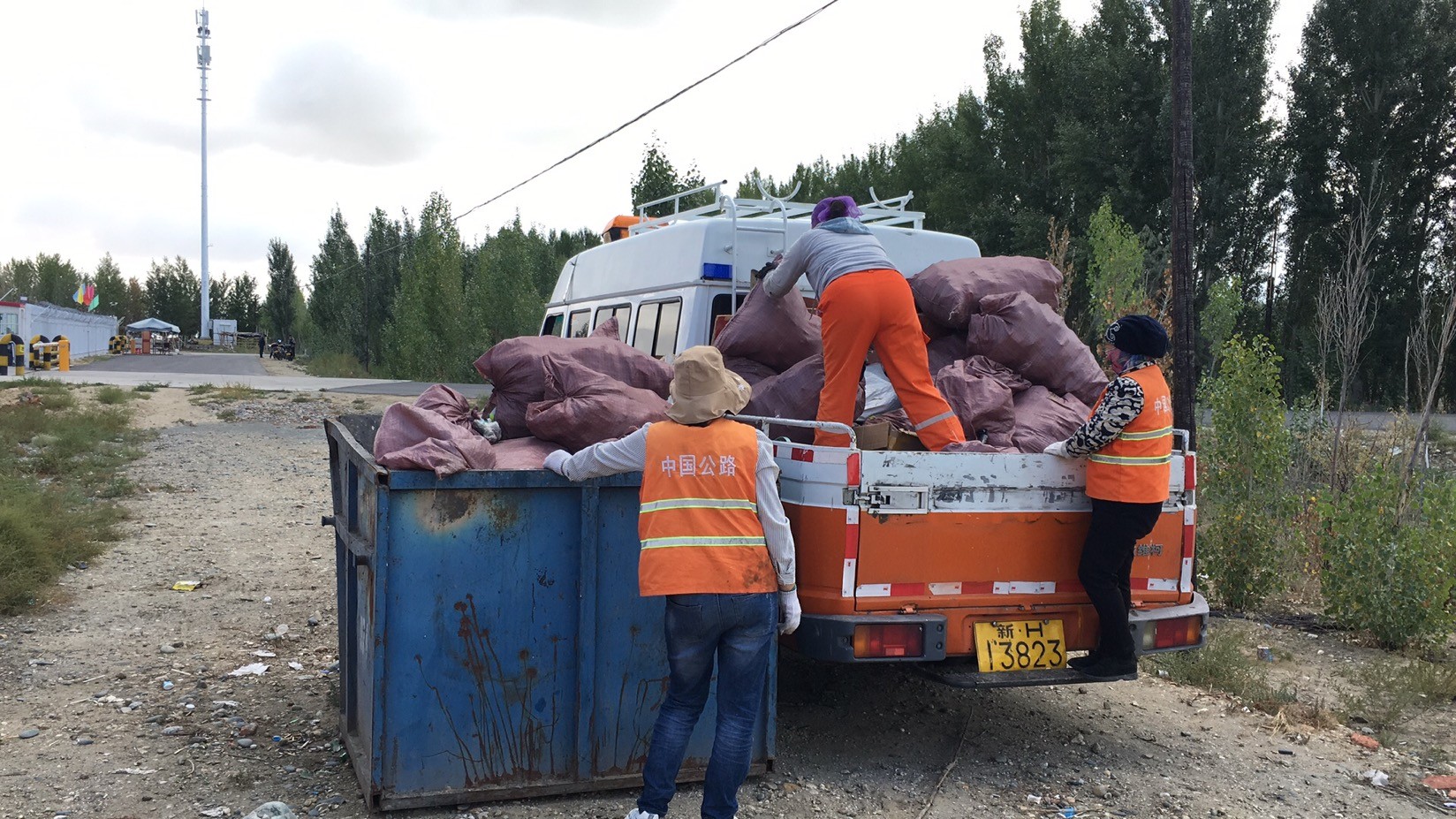 哈巴河公路管理分局职工将垃圾放置大垃圾箱内   图：吐尔逊江·哈斯木.jpg