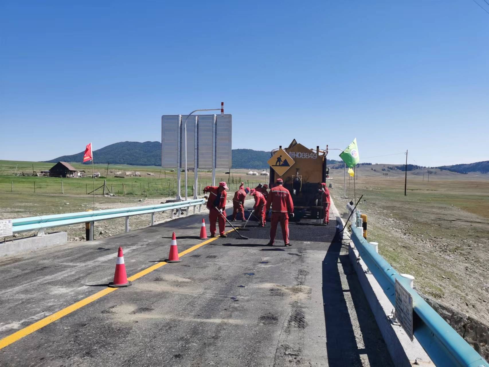 烈日炎炎下，北屯分局干部职工修补沥青路面中  图：唐伟.jpg